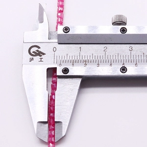 Macro shot showing measurement of 2.5mm pink faceted zircon beads for jewelry making