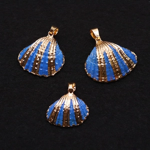 Macro shot of seashell pendants with blue enamel finish and golden metallic plating