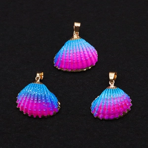 Detailed close-up of three rainbow gradient shell pendants with gold plated metal edges