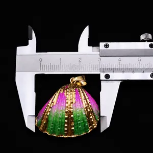Detail view of a 3cm pink and green gradient shell pendant with gold electroplated edges