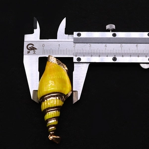 Macro shot measuring a 1.8cm yellow sea shell pendant with gold plating and metal trim