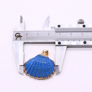 Macro view showing 2.7cm width of a blue shell pendant with gold plated edges and radial texture