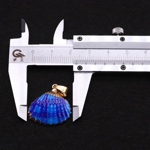 Pied à coulisse montrant la largeur de 2,8 cm du pendentif coquillage bleu et doré