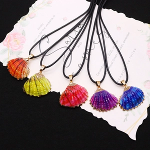 Ensemble de cinq pendentifs en coquillage colorés avec bords dorés et colliers cordon noir