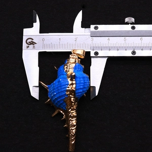 Detalle del colgante de caracola azul con borde dorado mostrando medida de 30mm en calibre
