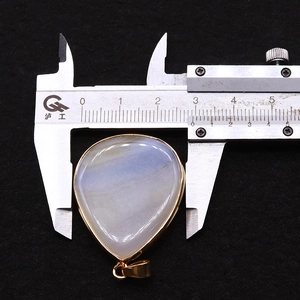 Detailed view of teardrop agate pendant measured with caliper showing 33mm width