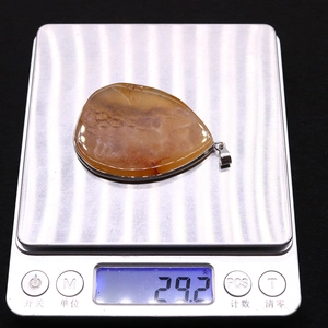 Detailed view of teardrop agate pendant weighing 29.2 grams on a digital scale