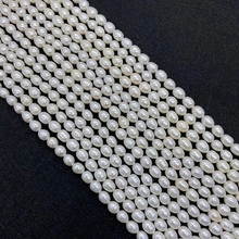 Close-up of white oval freshwater pearls arranged on a black textured background