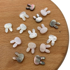 Detail of bunny-shaped natural shell beads with iridescent mother of pearl luster