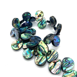 Gros plan de perles d'abalone en forme de poire avec des reflets irisés naturels