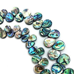 Gros plan de perles naturelles en nacre d'abalone en forme de goutte aux reflets irisés