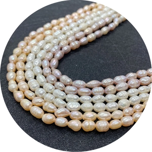 Natural freshwater rice pearls in white pink and purple colors on a black background