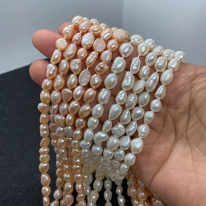 Detailed view of hand holding natural baroque freshwater pearl strands in mixed colors