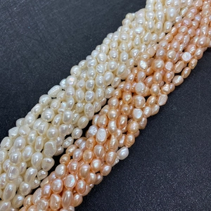Macro shot of natural baroque freshwater pearl strands in white and peach for DIY jewelry