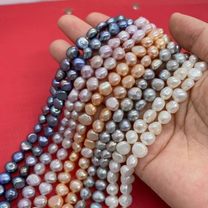Close-up of multicolored natural freshwater pearls held in hand for DIY jewelry making
