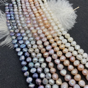 Baroque natural freshwater pearl beads in mixed colors arranged on black texture background