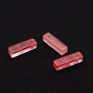 Detalle macro de tres colgantes rectangulares de cuarzo fresa rosa con texturas naturales
