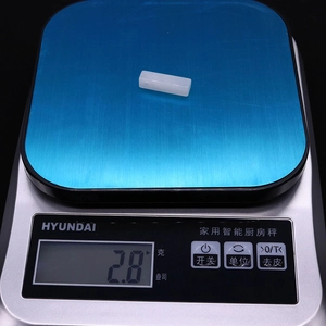 Detalle de un colgante de ágata blanca de 2,8g en una báscula digital para joyas DIY