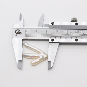 Macro detail of a 25.5mm natural white baroque pearl measured with a caliper tool