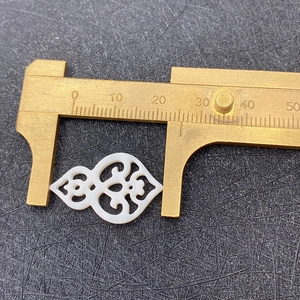 Detailaufnahme eines 24mm Muschelanhängers mit durchbrochenem Muster und Messschieber