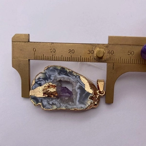 Messen des breiten Naturachat-Anhängers mit lila Kristall-Druse und goldplattiertem Rand