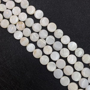 Macro view of flat round natural white shell beads with iridescent luster for DIY jewelry