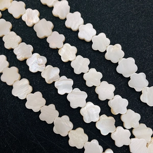 Macro shot of natural white shell flower beads with iridescent pearly luster finish