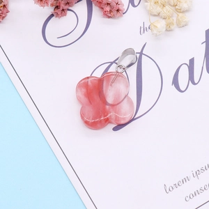 Detailed view of translucent flower-shaped crystal pendant with silver bail on decorative card