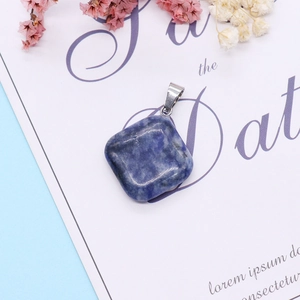 Gros plan d'un pendentif losange en pierre bleue naturelle avec bélière argentée