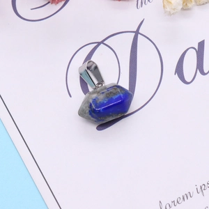 Macro detail of a double-pointed lapis lazuli stone pendant with silver metallic clasp