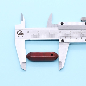 Detailed measurement of a dark red hexagonal stone pendant using a silver caliper tool