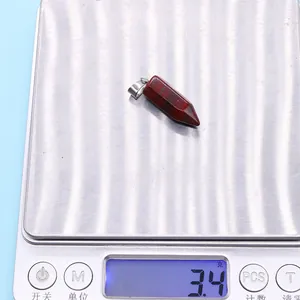 Macro shot of a red natural stone hexagonal pendant being weighed at 3.4g for DIY jewelry
