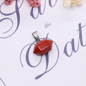 Macro shot of red jasper stone pendant with geometric facets and silver clasp