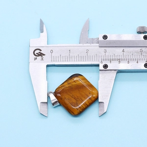Tiger eye stone square pendant measured with calipers showing 25mm dimensions