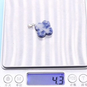 Macro scale shot of blue marble stone clover pendant showing a weight of 4.3 grams