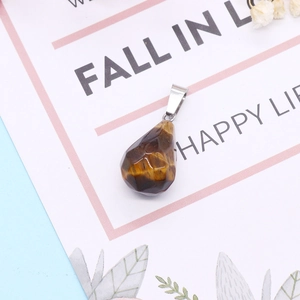 Macro shot of a faceted tiger eye gemstone teardrop pendant with silver metal bail