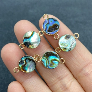 Detailed view of five natural abalone shell round double-hole charms with gold edges