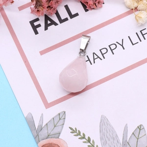Detailed close-up of a faceted pear-shaped rose quartz pendant with silver metal bail