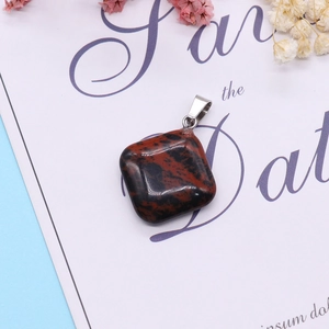 Polished mahogany obsidian cushion pendant with silver clasp on decorative background