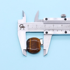 Detail showing 21mm apple-shaped tiger eye stone pendant measured by a digital caliper