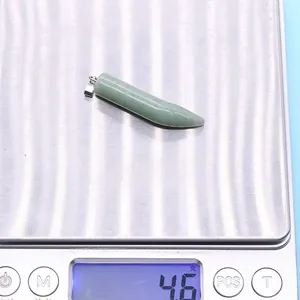 Detailed view of light green stone horn pendant weighing 4.6 grams on digital scale