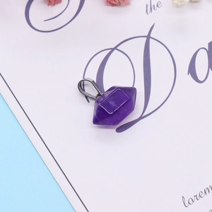 Purple hexagonal crystal point pendant with metallic clasp on decorative white card