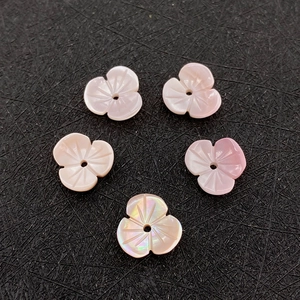Macro-detail van vijf gesneden roze schelpen bloemkralen voor DIY sieraden
