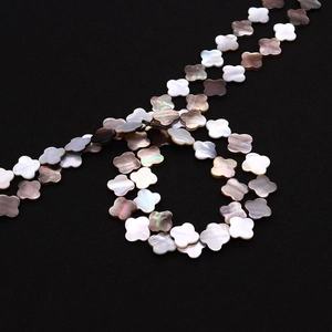 Vue macro de perles trèfle en nacre naturelle pour la création de bijoux DIY