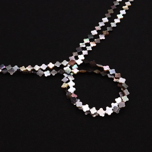 Gros plan de perles de trèfle en nacre naturelle aux reflets irisés pour bijoux