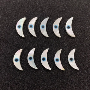 Détails macro de perles en nacre en forme de lune avec symboles mauvais œil pour bijoux