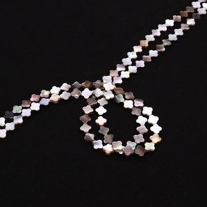 Détail macro de perles de nacre naturelle en forme de trèfle à quatre feuilles