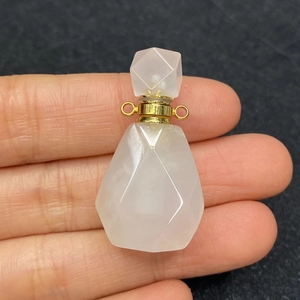 Dettaglio macro del ciondolo boccetta di profumo in quarzo rosa con taglio a faccette