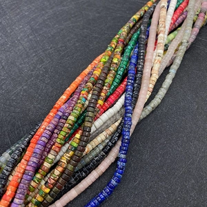 Dettaglio di perline heishi da 2x4mm colorate in varie texture e venature di pietra naturale