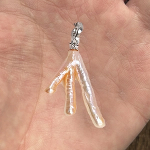 Dettaglio del pendente con perla barocca naturale e design a forma di artiglio